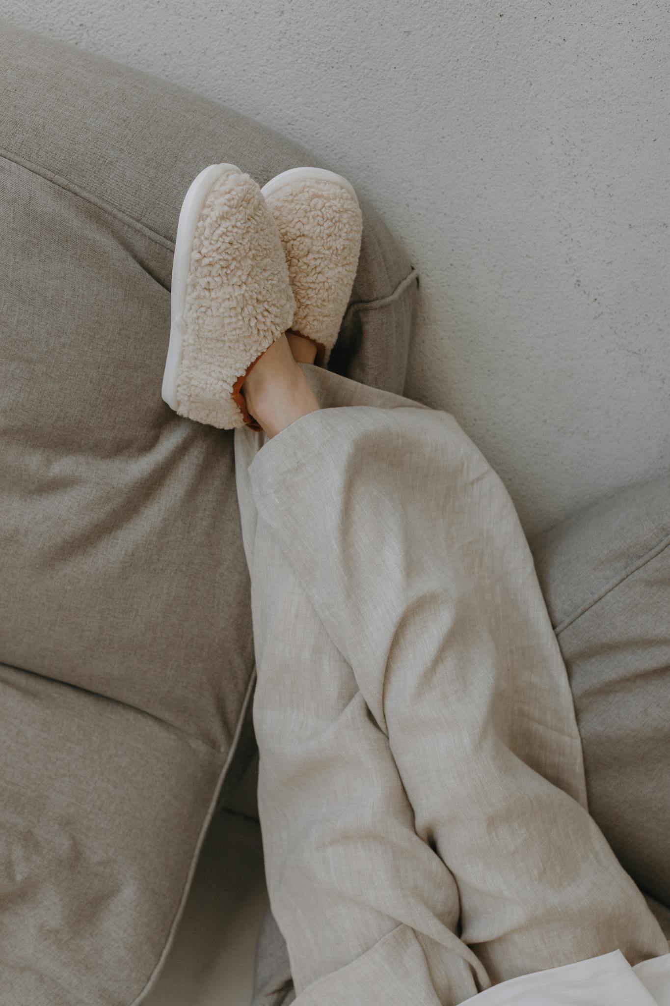 Relaxed person lounging indoors with plush slippers, conveying warmth and comfort.